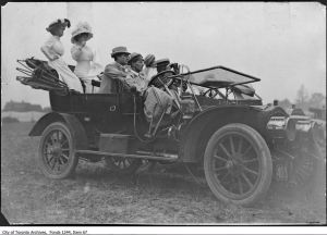 People in automobile watching first ever flight in Weston July 1910